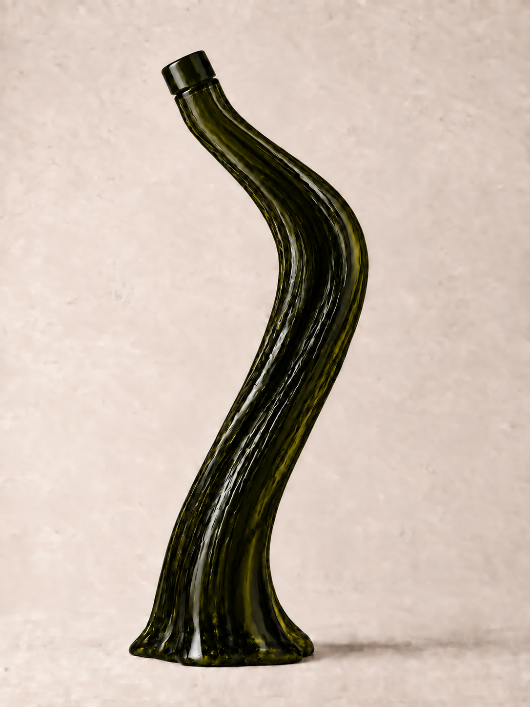 Olive oil in a sculptural dark olive-green glass bottle with a simple cylindrical glass cap, an S-curved silhouette, flowing ridges, and a flared base.